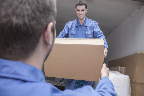 Movers safely carrying bulky furniture through a Nottinghill property